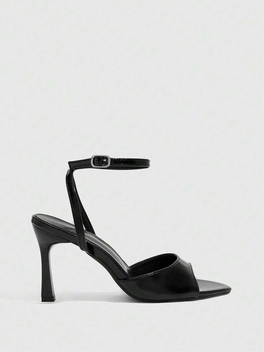 Pair of women's black high heel sandals with open toe design, slim stiletto heel, and adjustable ankle buckle strap.