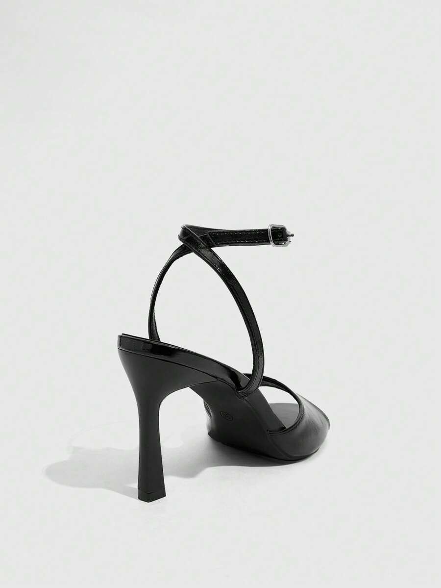 Pair of women's black high heel sandals with open toe design, slim stiletto heel, and adjustable ankle buckle strap.