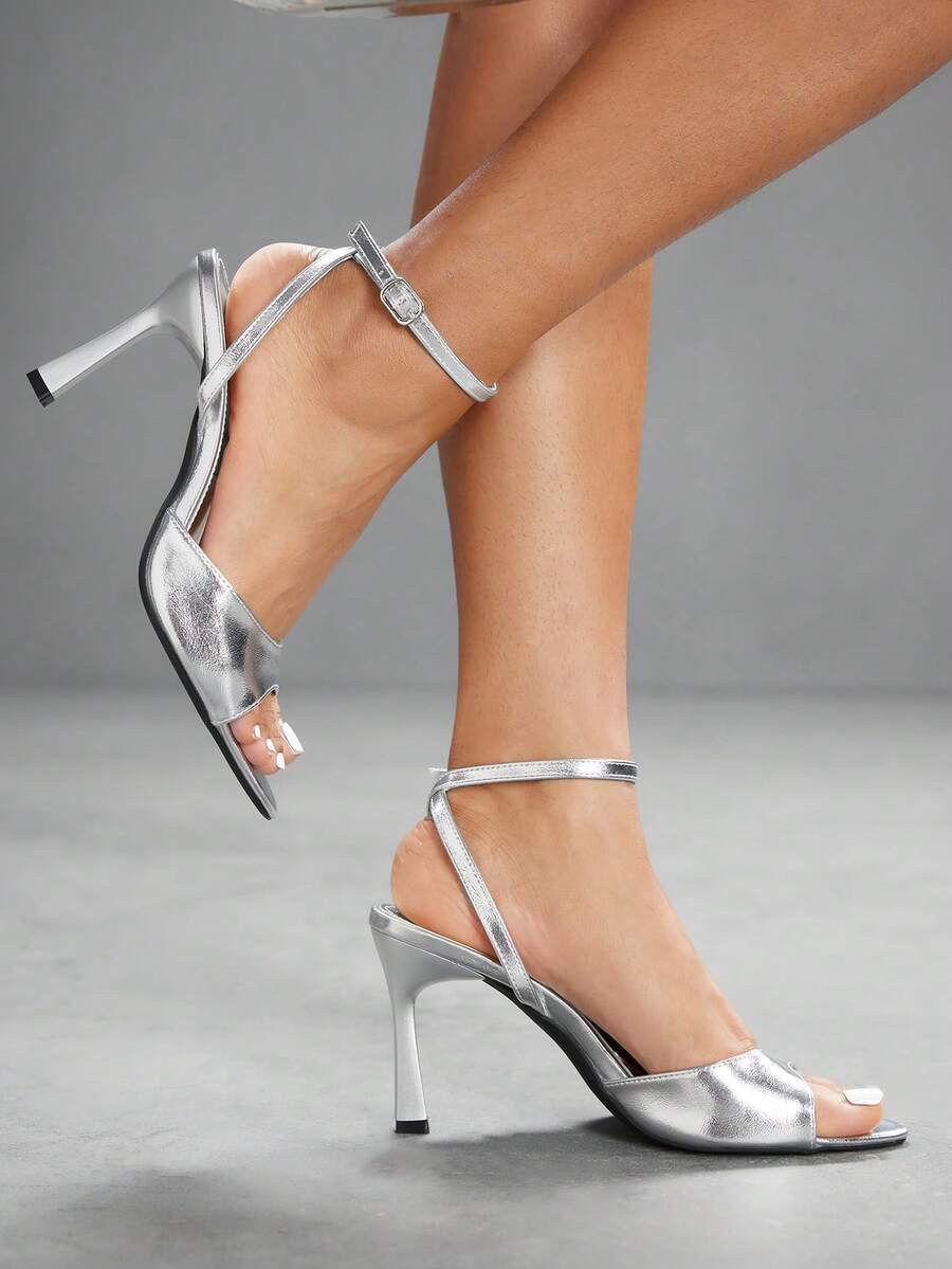 Pair of women's black high heel sandals with open toe design, slim stiletto heel, and adjustable ankle buckle strap.