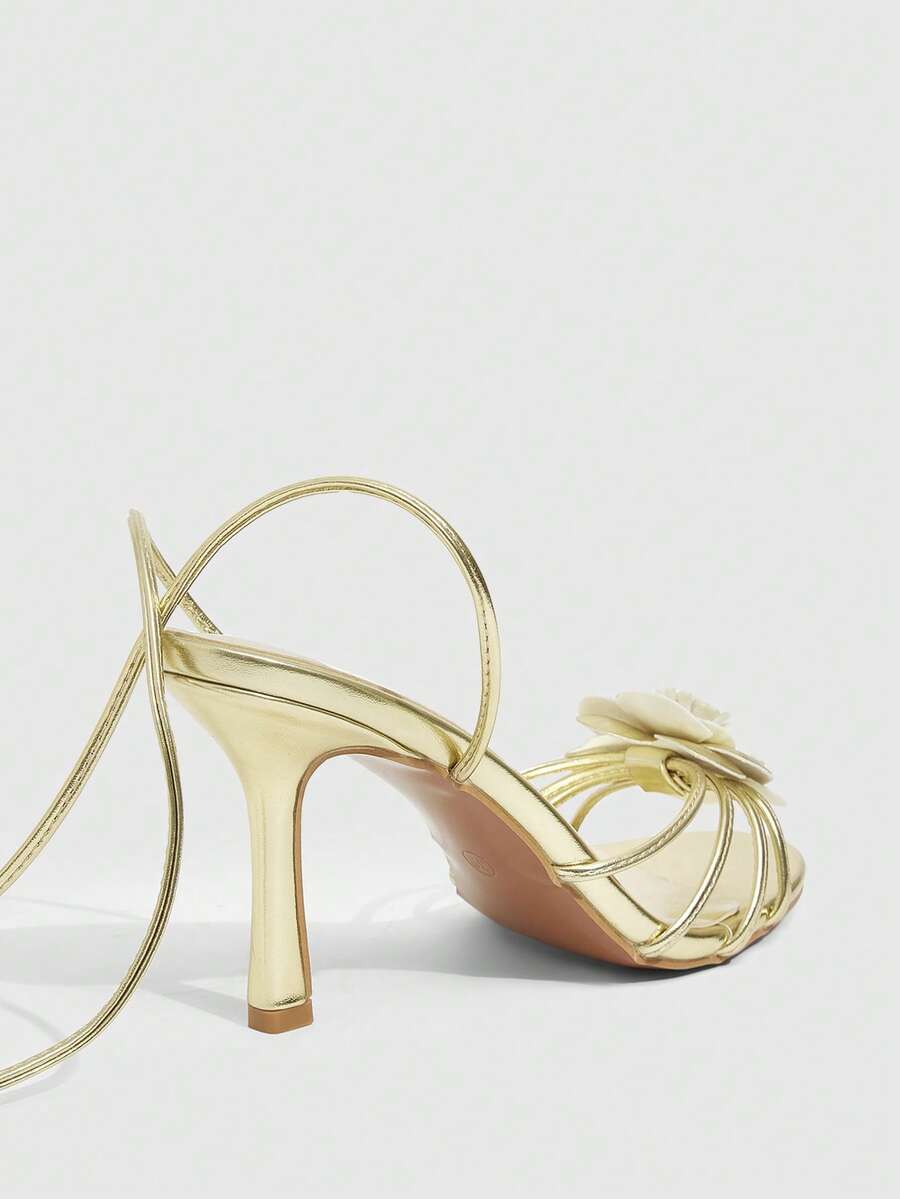 Women's round toe high heel sandals with brown flannel finish, floral trim detail, and strappy lace-up stiletto design.