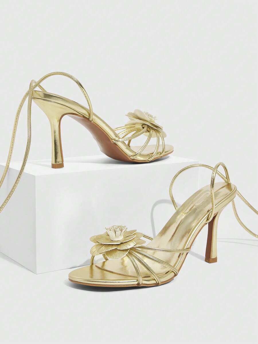 Women's round toe high heel sandals with brown flannel finish, floral trim detail, and strappy lace-up stiletto design.