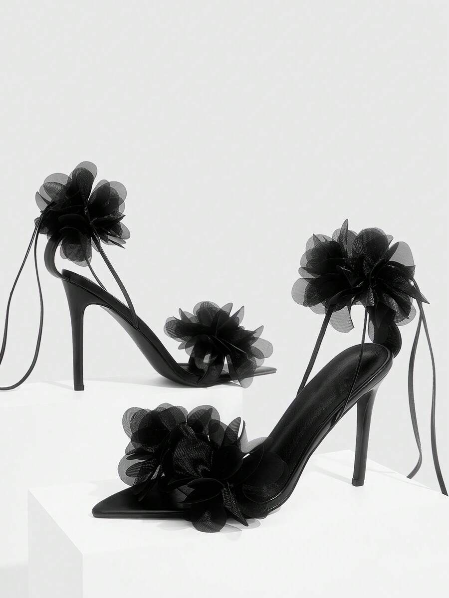 Women's open toe heeled sandals featuring 3D floral decor, satin lace-up ankle straps, and stiletto high heels.