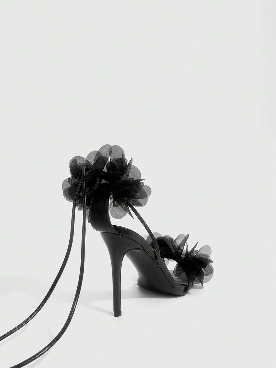 Women's open toe heeled sandals featuring 3D floral decor, satin lace-up ankle straps, and stiletto high heels.