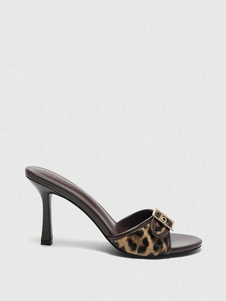 Women's brown leopard print high heel mule sandals with gold-tone buckle and grommet eyelet accents.