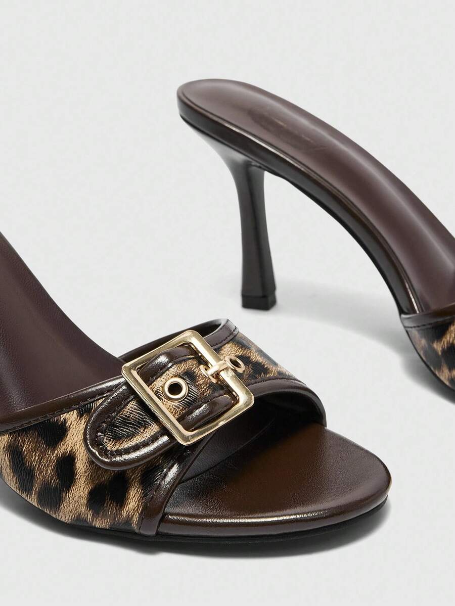 Women's brown leopard print high heel mule sandals with gold-tone buckle and grommet eyelet accents.