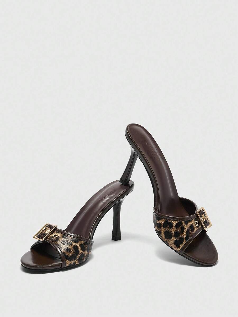 Women's brown leopard print high heel mule sandals with gold-tone buckle and grommet eyelet accents.