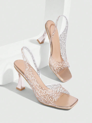 Women's square toe heeled sandals with clear straps, sparkling rhinestone embellishments, and a high pyramid heel.
