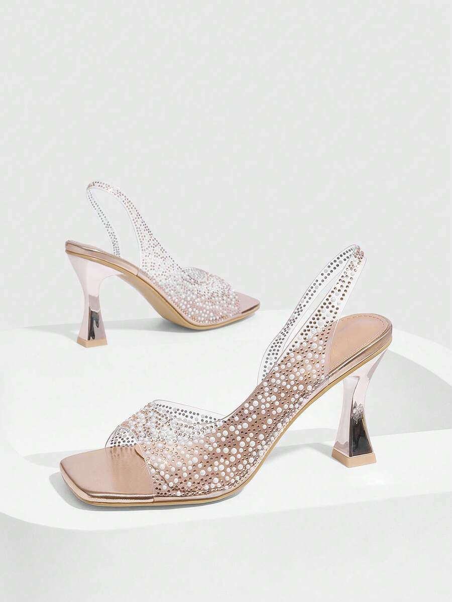 Women's square toe heeled sandals with clear straps, sparkling rhinestone embellishments, and a high pyramid heel.