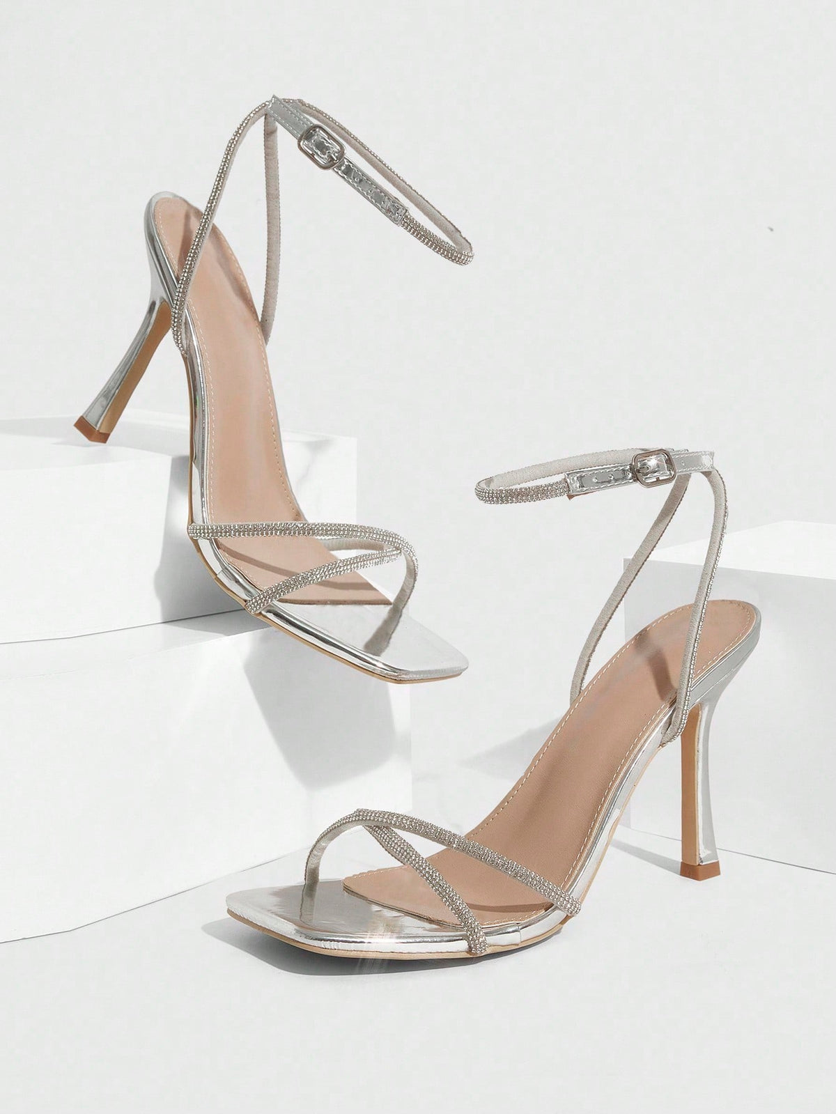Champagne rhinestone ankle strap heeled sandals with open toe and high stiletto heel for women.