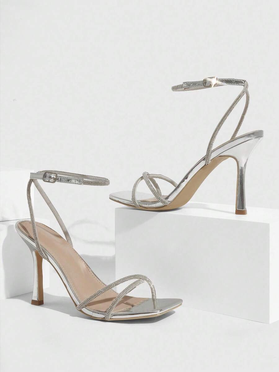 Champagne rhinestone ankle strap heeled sandals with open toe and high stiletto heel for women.