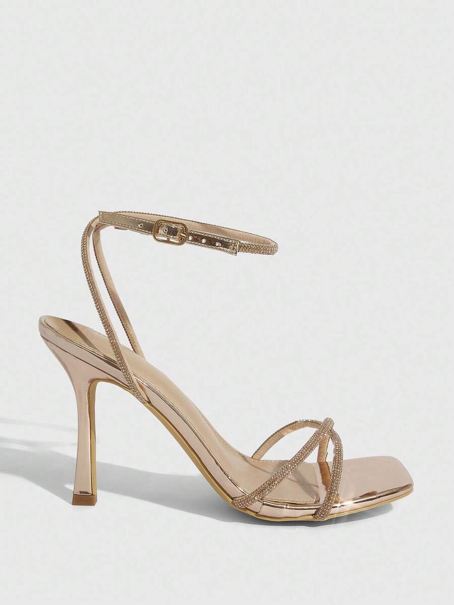 Champagne rhinestone ankle strap heeled sandals with open toe and high stiletto heel for women.