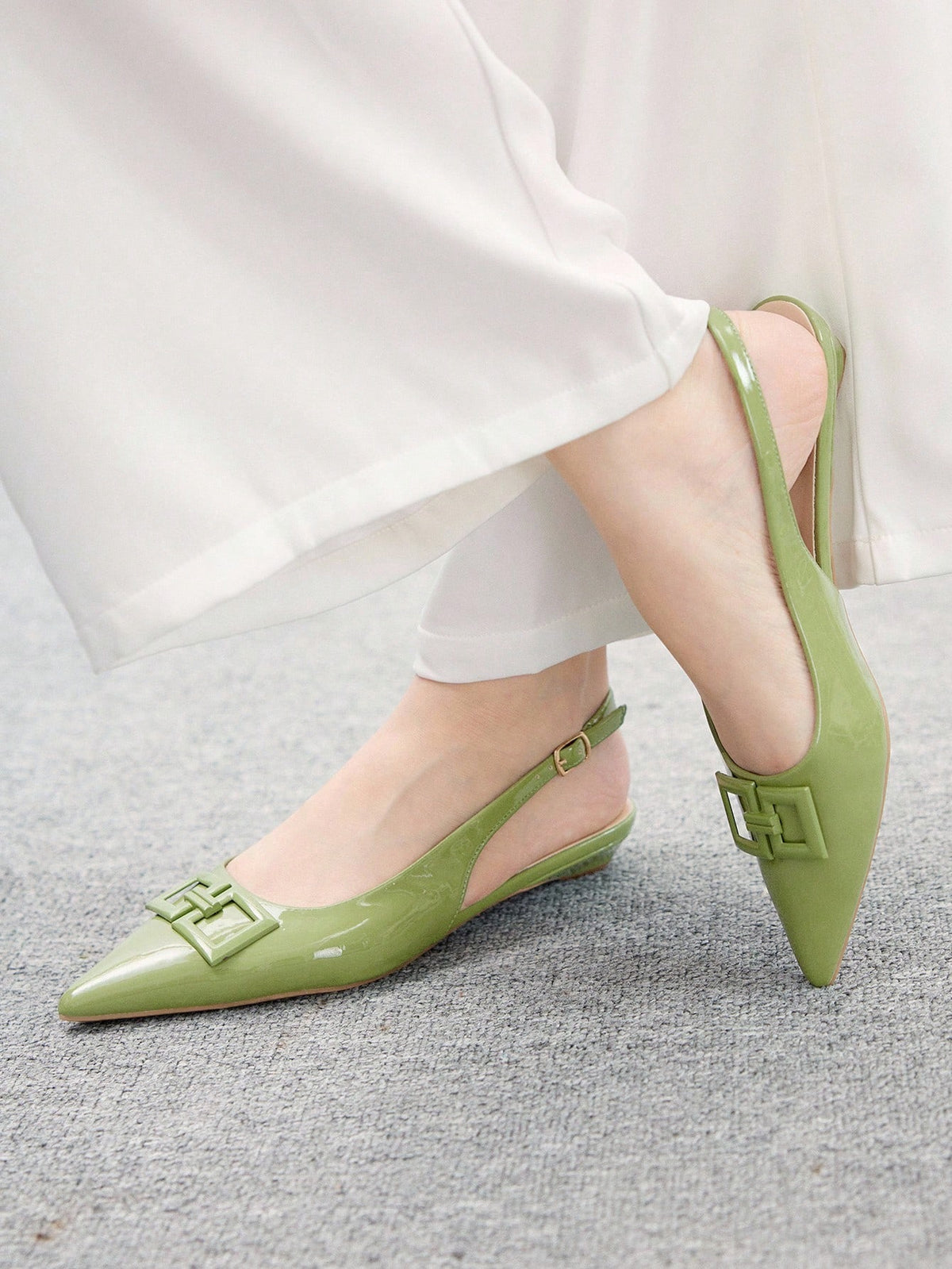 Women's pointed toe low wedge flat shoes crafted in PU leather with a slingback strap and stylish metal buckle detail.