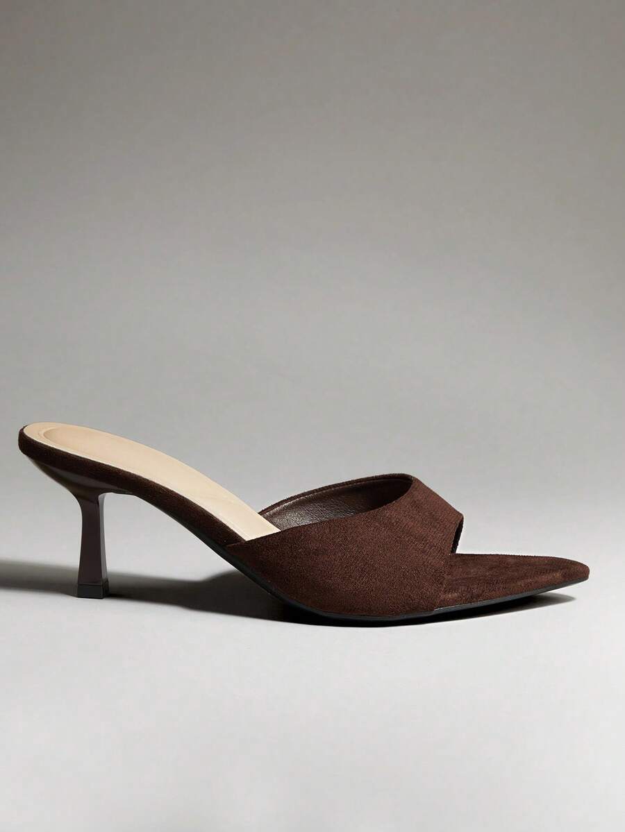 Black pointy toe kitten heel shoes for women featuring a sleek cut out mule design and glossy patent leather finish.