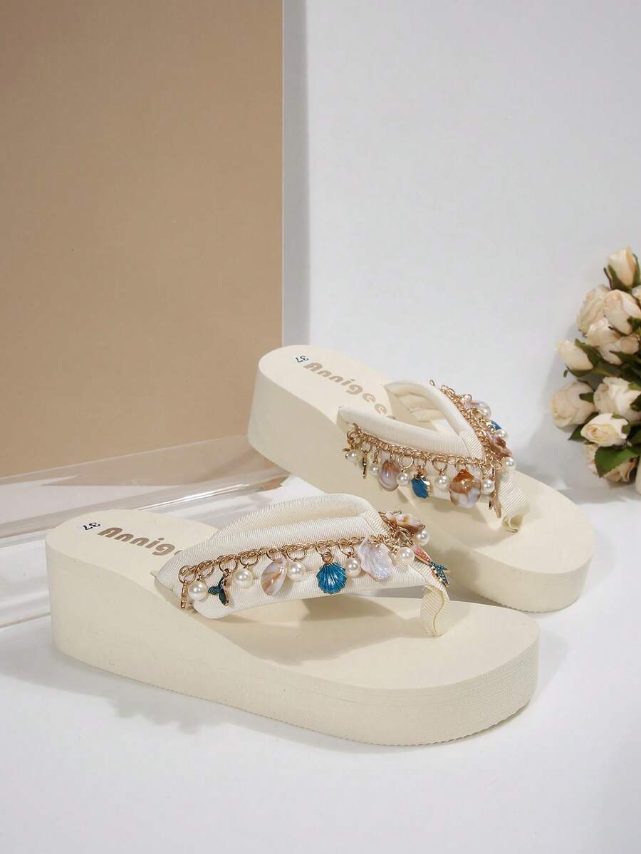 Beige platform wedge flip flop slippers featuring decorative chain and shell details with EVA sole for women.