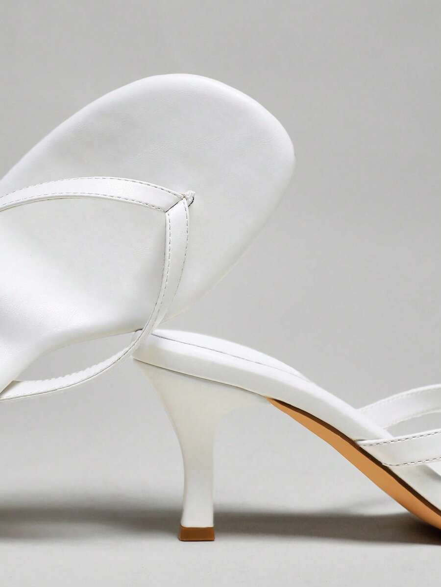 Women's minimalist black PU leather thong heel sandals featuring kitten heels and rhinestone accents