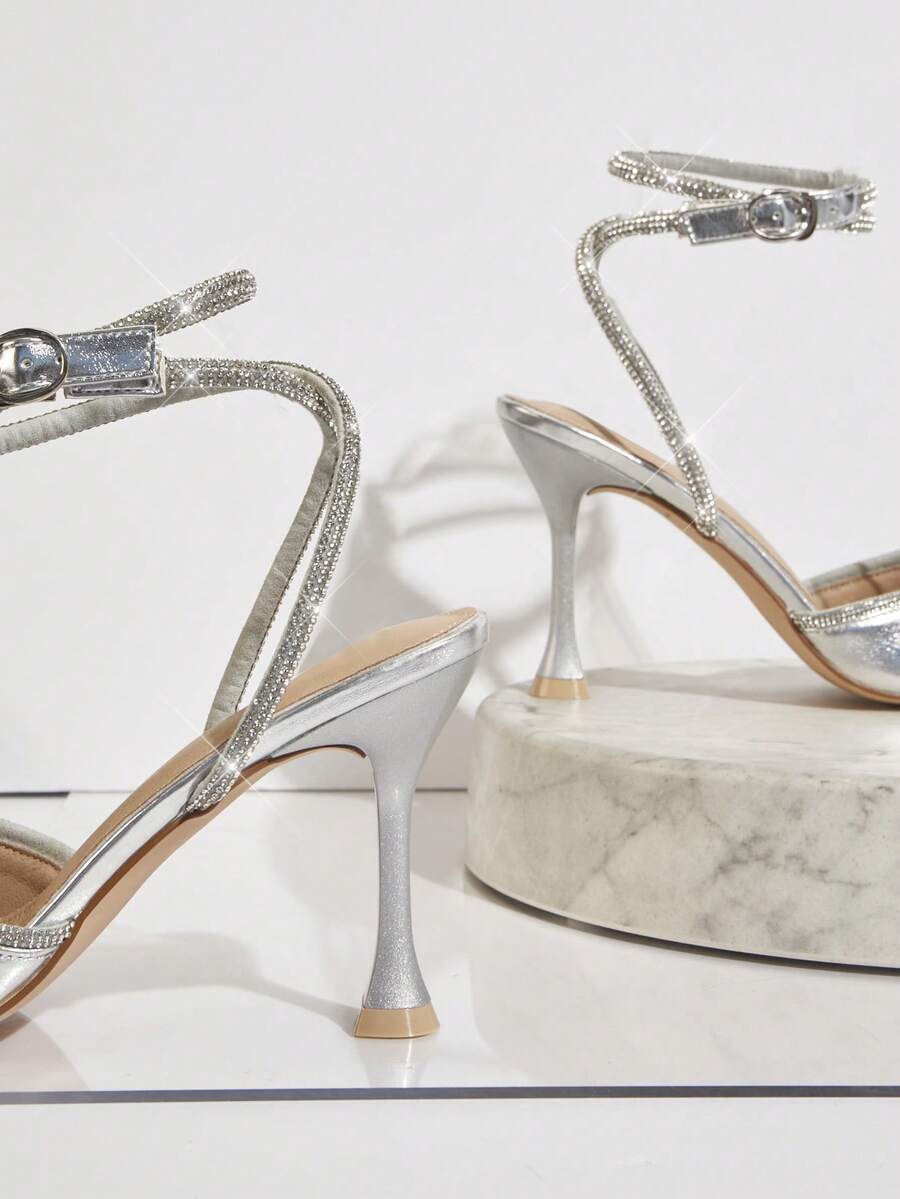 Women's pointed toe stiletto heel slingback pumps in chocolate brown with double metal buckle strap details.