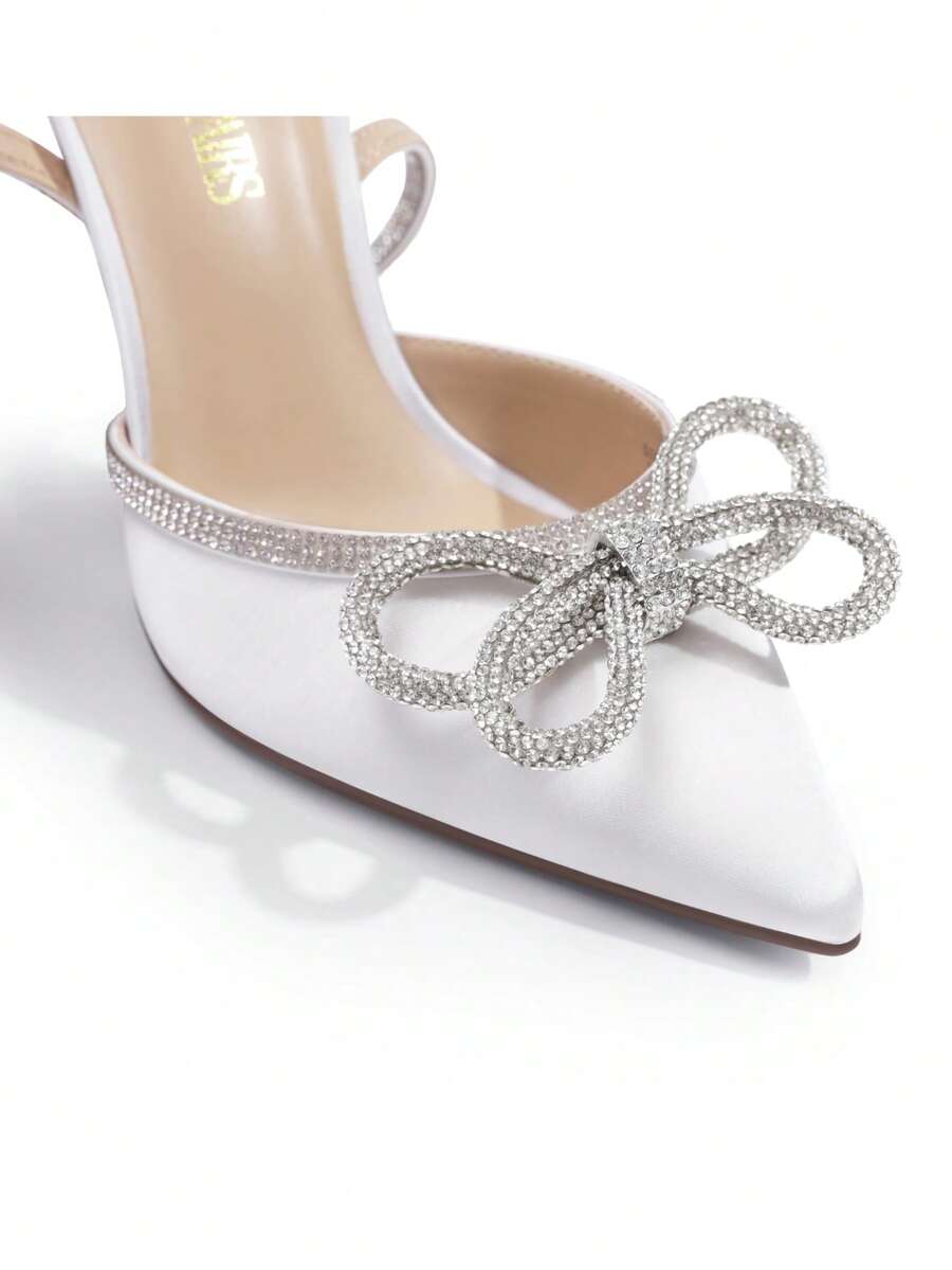 Women's rhinestone ankle strap high heels with pointed closed toe, strappy bow details, and stiletto heel for wedding and prom wear.