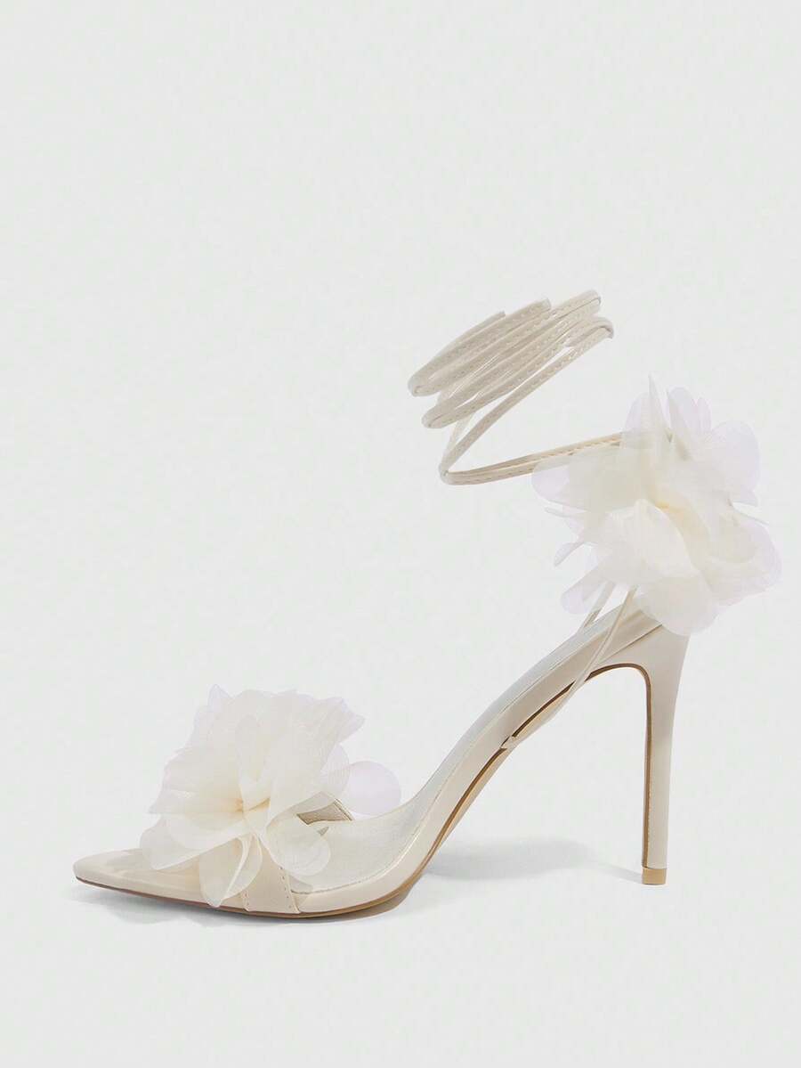 Women's open toe heeled sandals featuring 3D floral decor, satin lace-up ankle straps, and stiletto high heels.