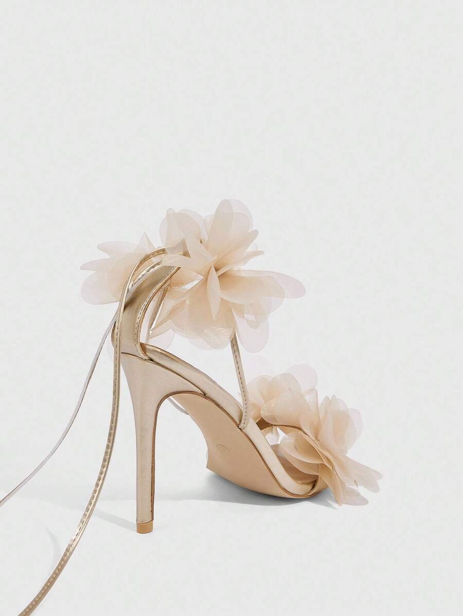 Women's open toe heeled sandals featuring 3D floral decor, satin lace-up ankle straps, and stiletto high heels.