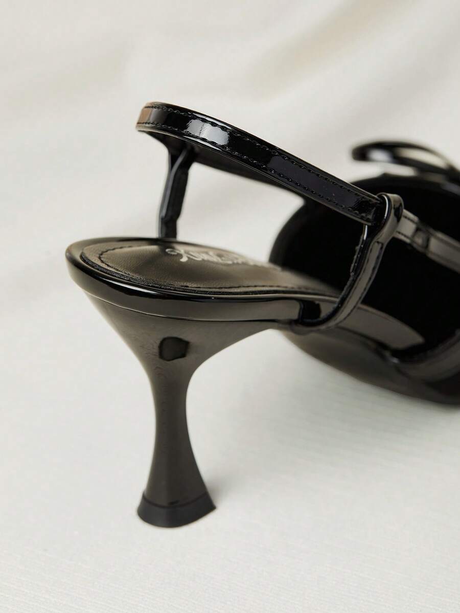 Women's black pointed toe slingback heels featuring a bowknot accent, closed toe design, adjustable buckle strap, and pyramid mid heel.