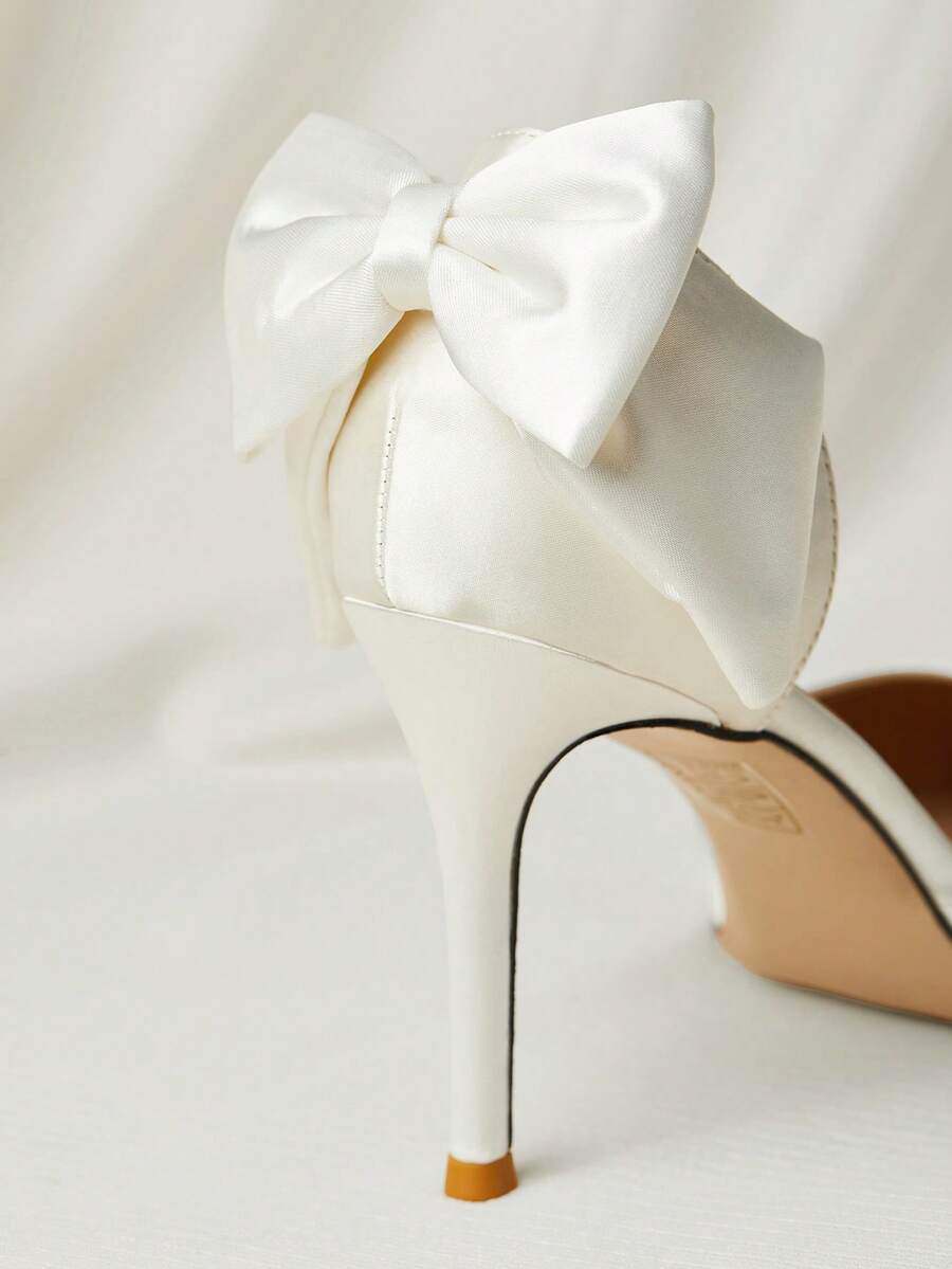 White satin bridal high heels with an elegant bow knot accent, pointed toe, and slingback stiletto heel for weddings and formal events.