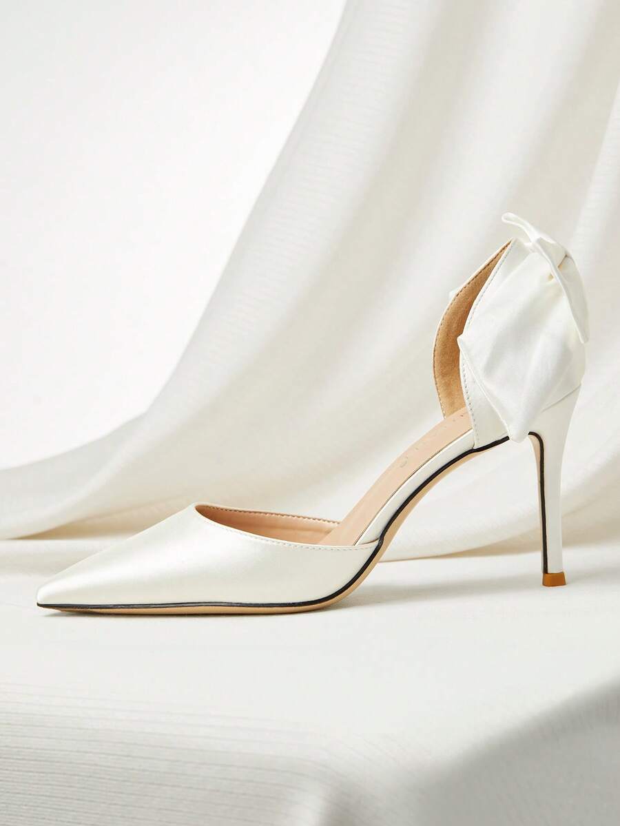 White satin bridal high heels with an elegant bow knot accent, pointed toe, and slingback stiletto heel for weddings and formal events.