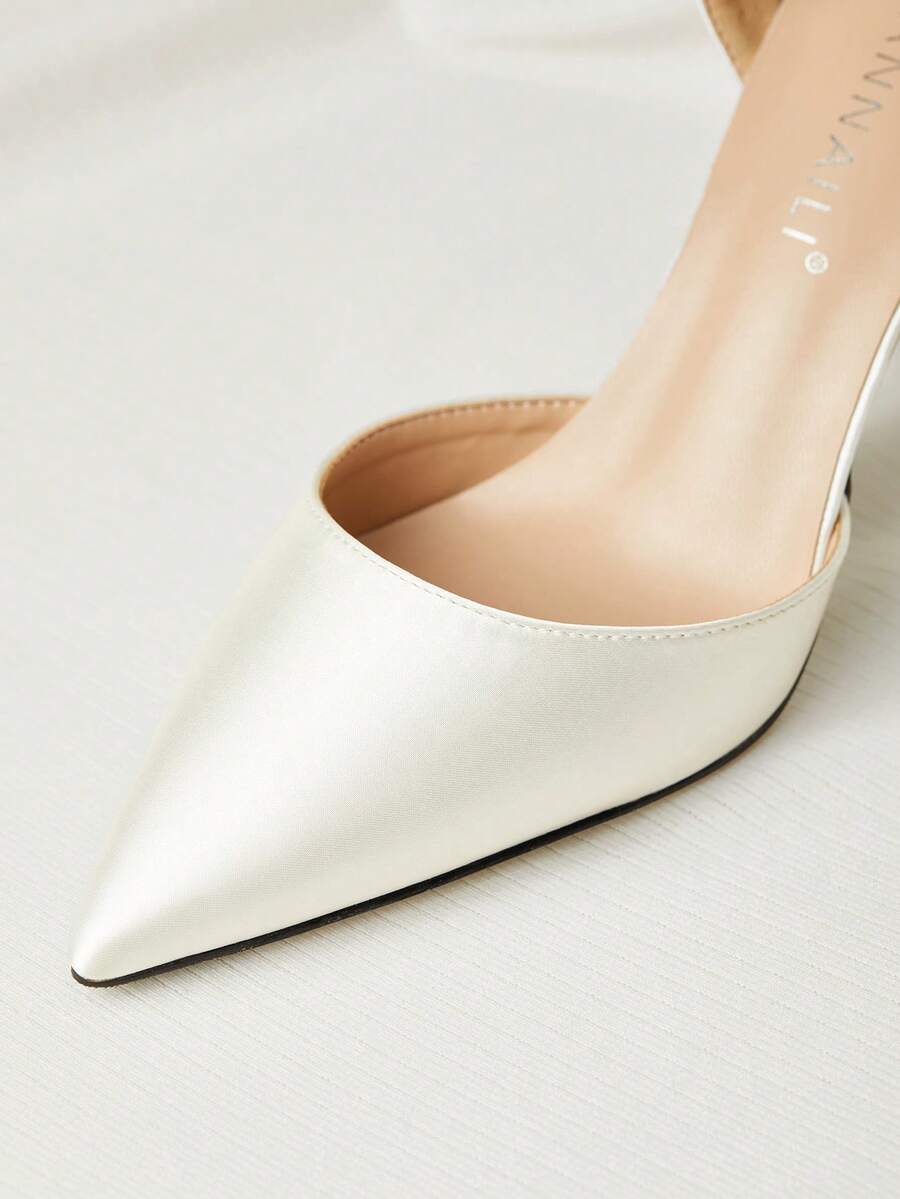 White satin bridal high heels with an elegant bow knot accent, pointed toe, and slingback stiletto heel for weddings and formal events.