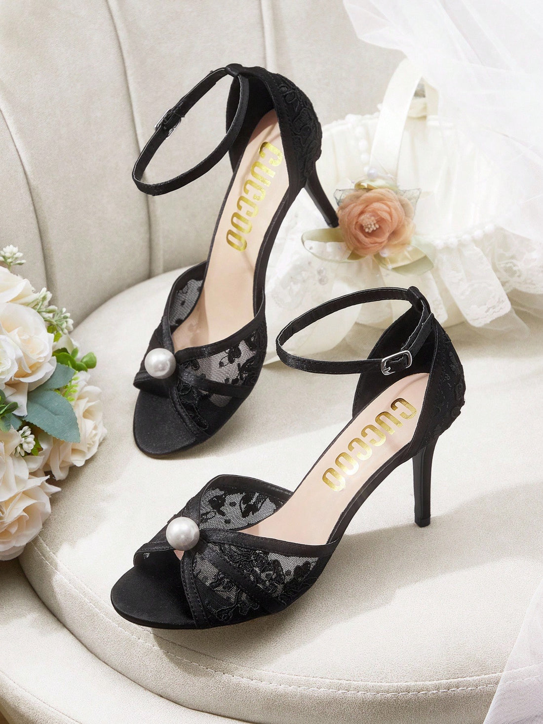 Beige high heel sandals with delicate lace overlay, pearl embellishments, stiletto heel, and adjustable ankle strap for bride and wedding party wear.