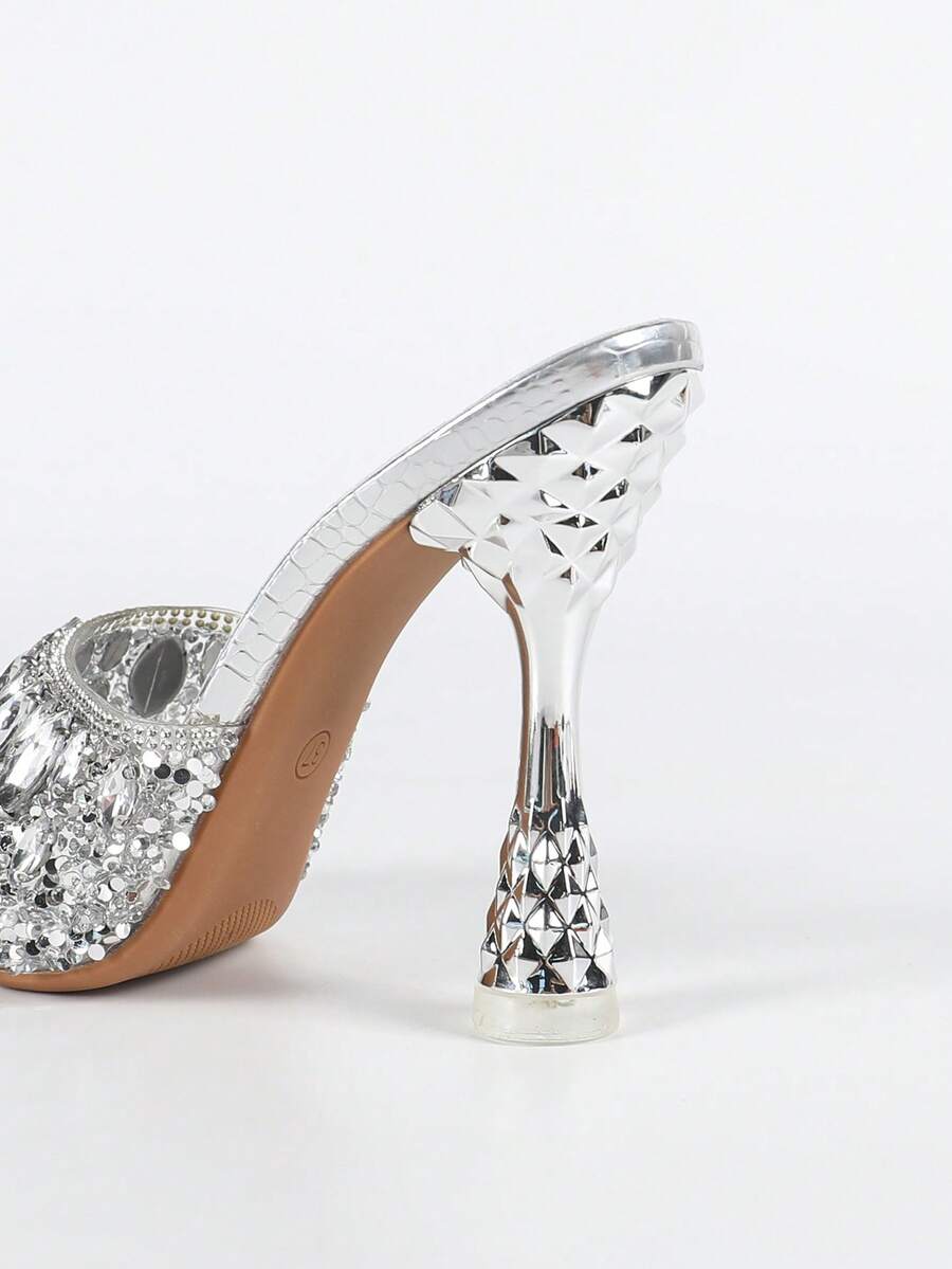 Women's metallic-plated high heeled sandals with shining rhinestone accents, sculptural stiletto heel, and open round toe.