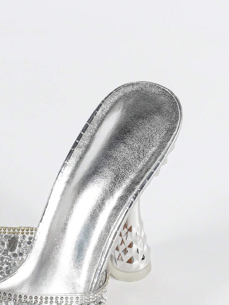 Women's metallic-plated high heeled sandals with shining rhinestone accents, sculptural stiletto heel, and open round toe.