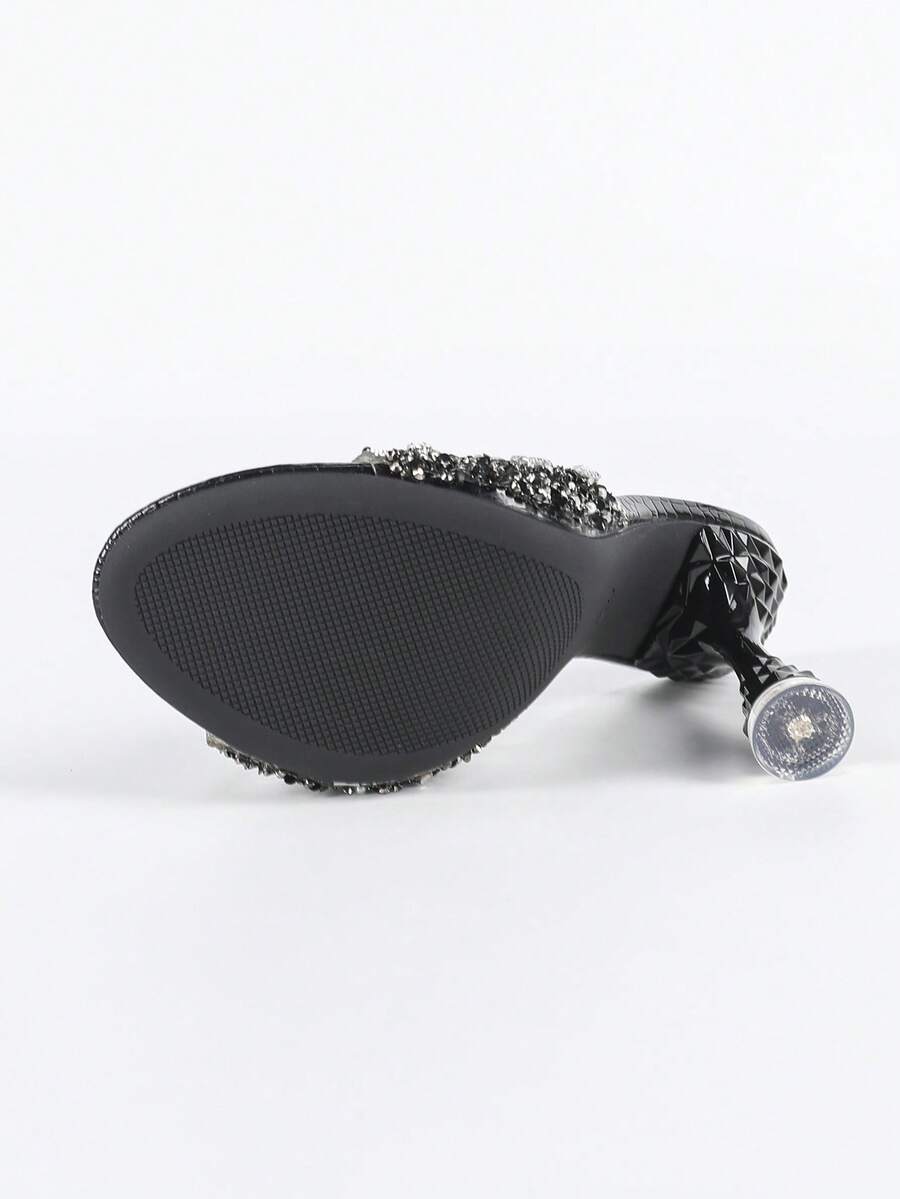 Women's metallic-plated high heeled sandals with shining rhinestone accents, sculptural stiletto heel, and open round toe.