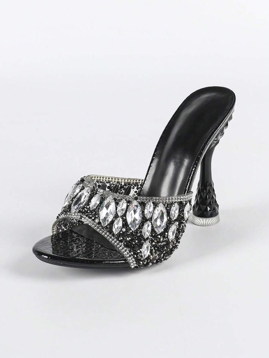 Women's metallic-plated high heeled sandals with shining rhinestone accents, sculptural stiletto heel, and open round toe.