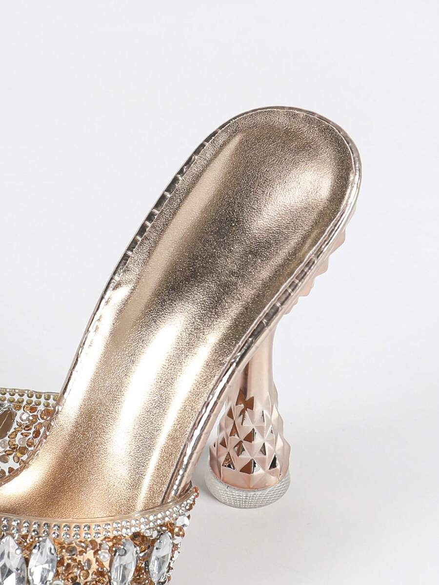 Women's metallic-plated high heeled sandals with shining rhinestone accents, sculptural stiletto heel, and open round toe.