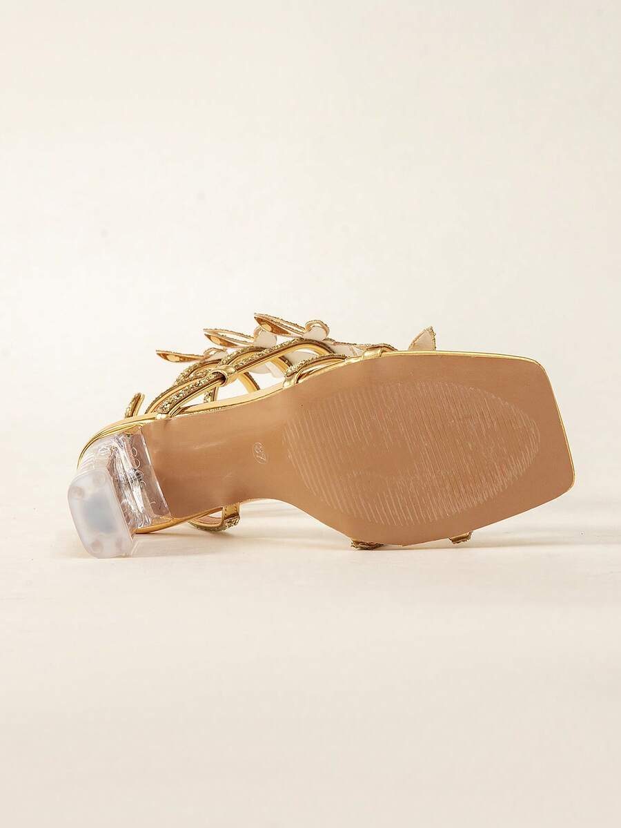 Women's gold high heel sandals with shimmering glass rhinestone straps, open toe, lace-up ankle tie, and asymmetrical sculptural heel.