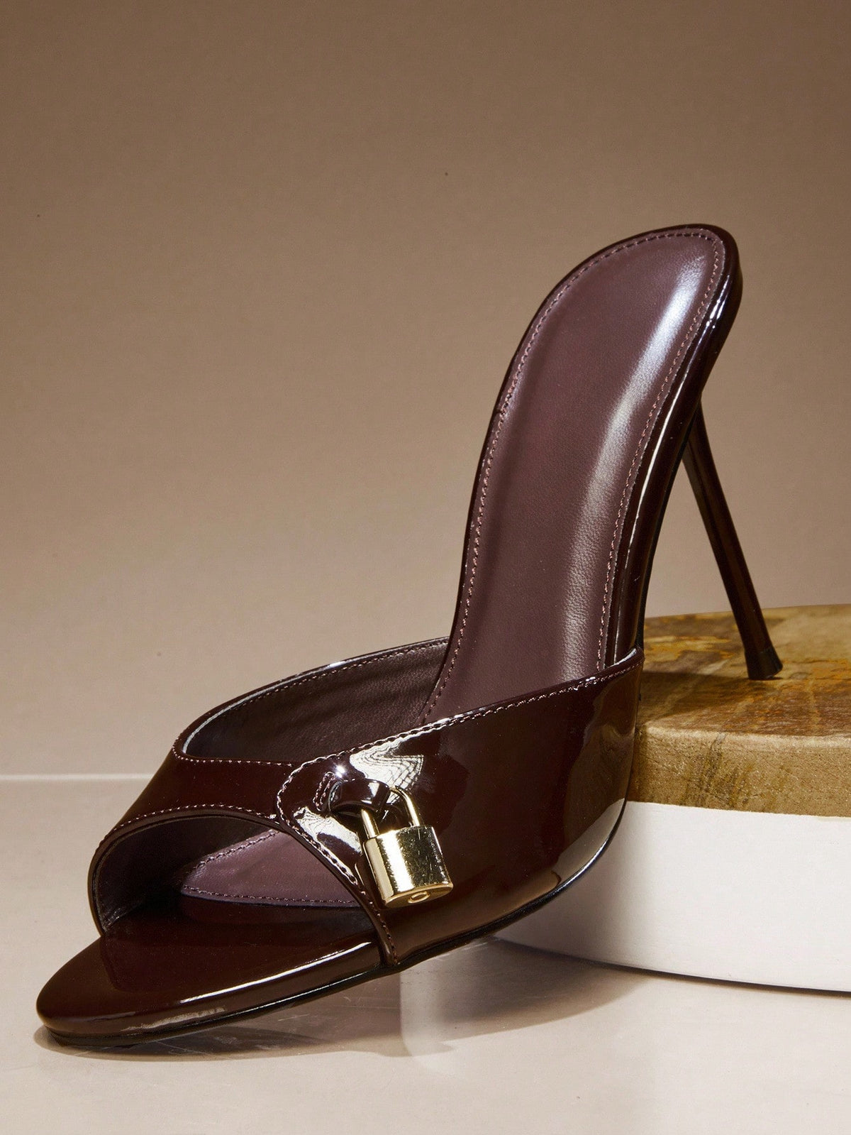 Women's slip-on heeled sandals with metal-coated stiletto heels and lock decoration in chocolate brown PU leather.