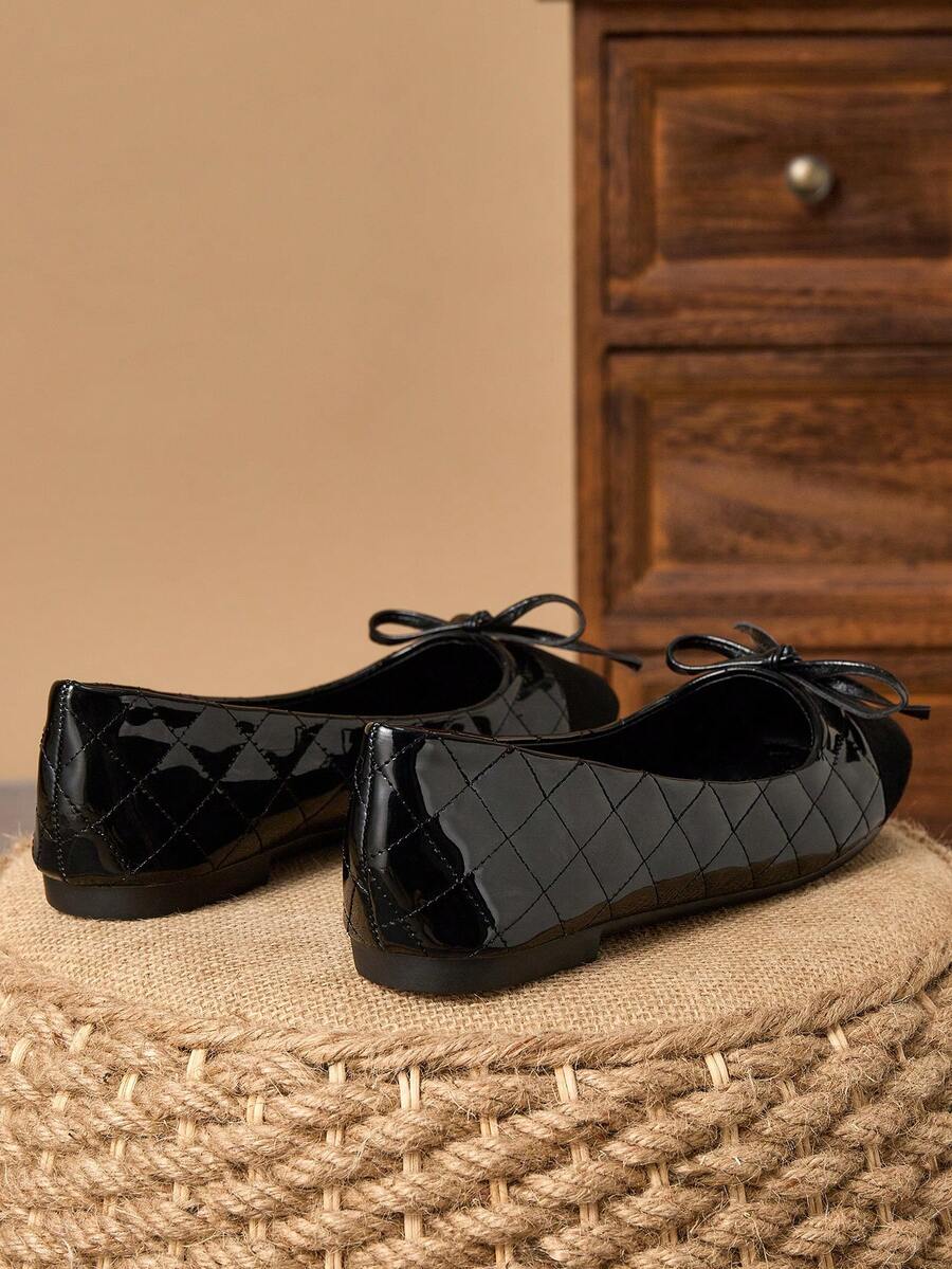 Pair of women's square toe slip-on flat shoes featuring a delicate bow detail and low vamp design.