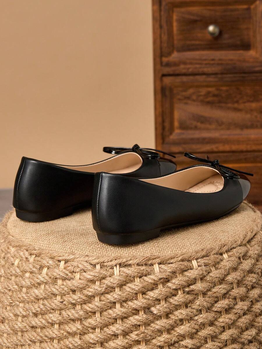 Pair of women's square toe slip-on flat shoes featuring a delicate bow detail and low vamp design.