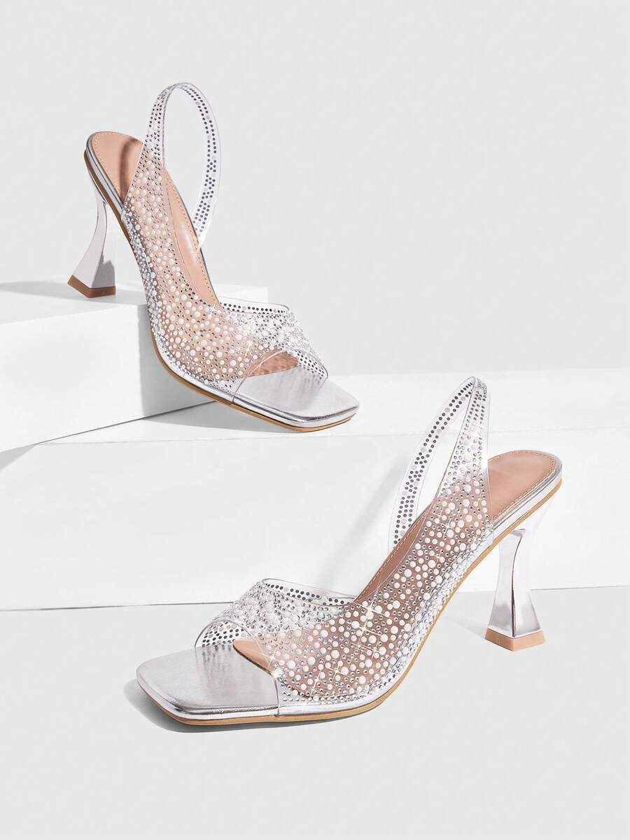 Women's square toe heeled sandals with clear straps, sparkling rhinestone embellishments, and a high pyramid heel.