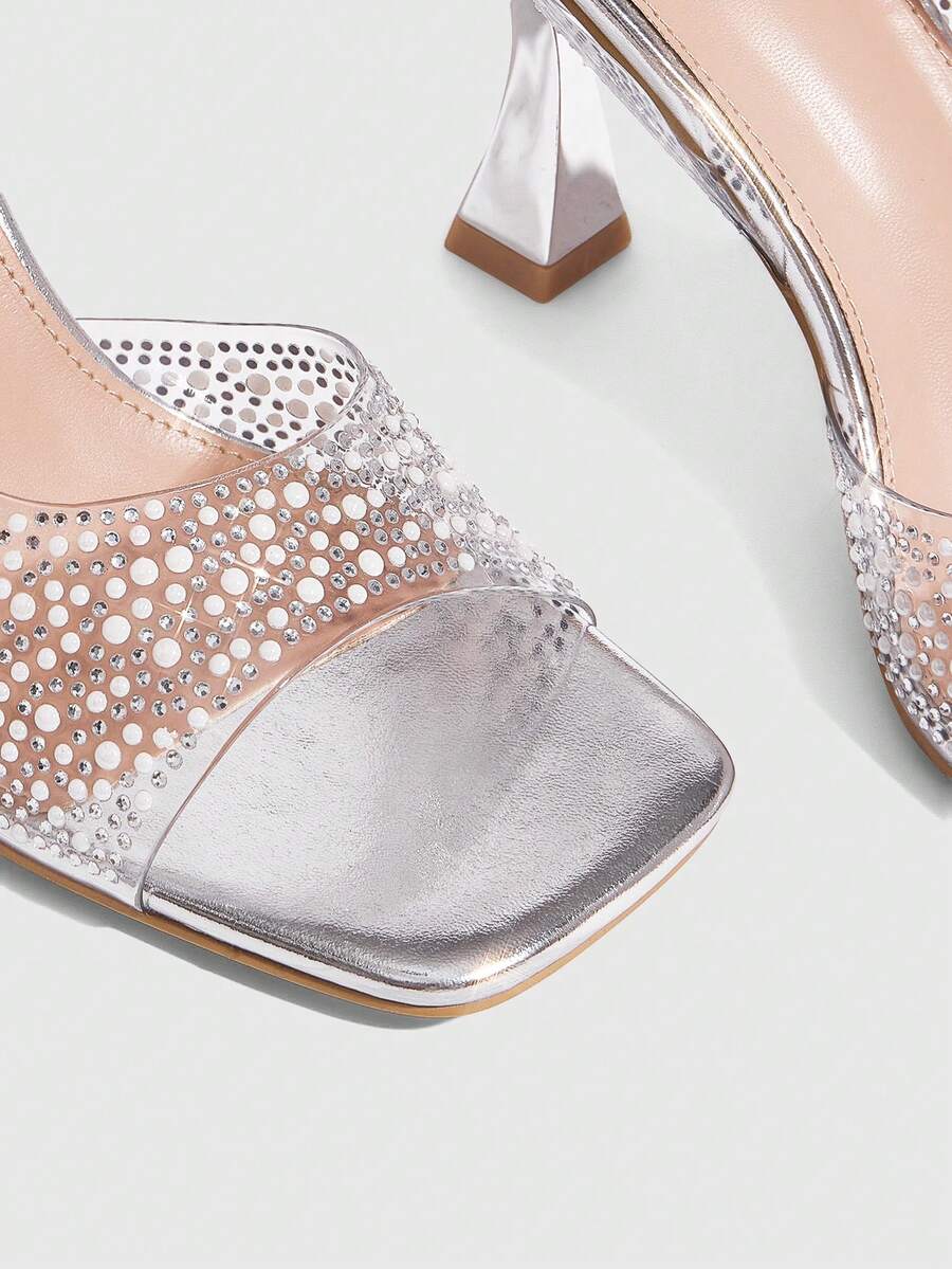 Women's square toe heeled sandals with clear straps, sparkling rhinestone embellishments, and a high pyramid heel.