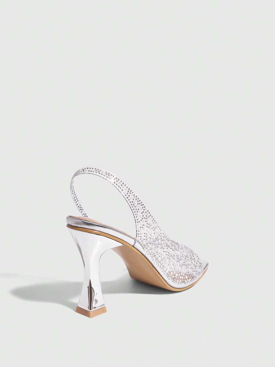 Women's square toe heeled sandals with clear straps, sparkling rhinestone embellishments, and a high pyramid heel.