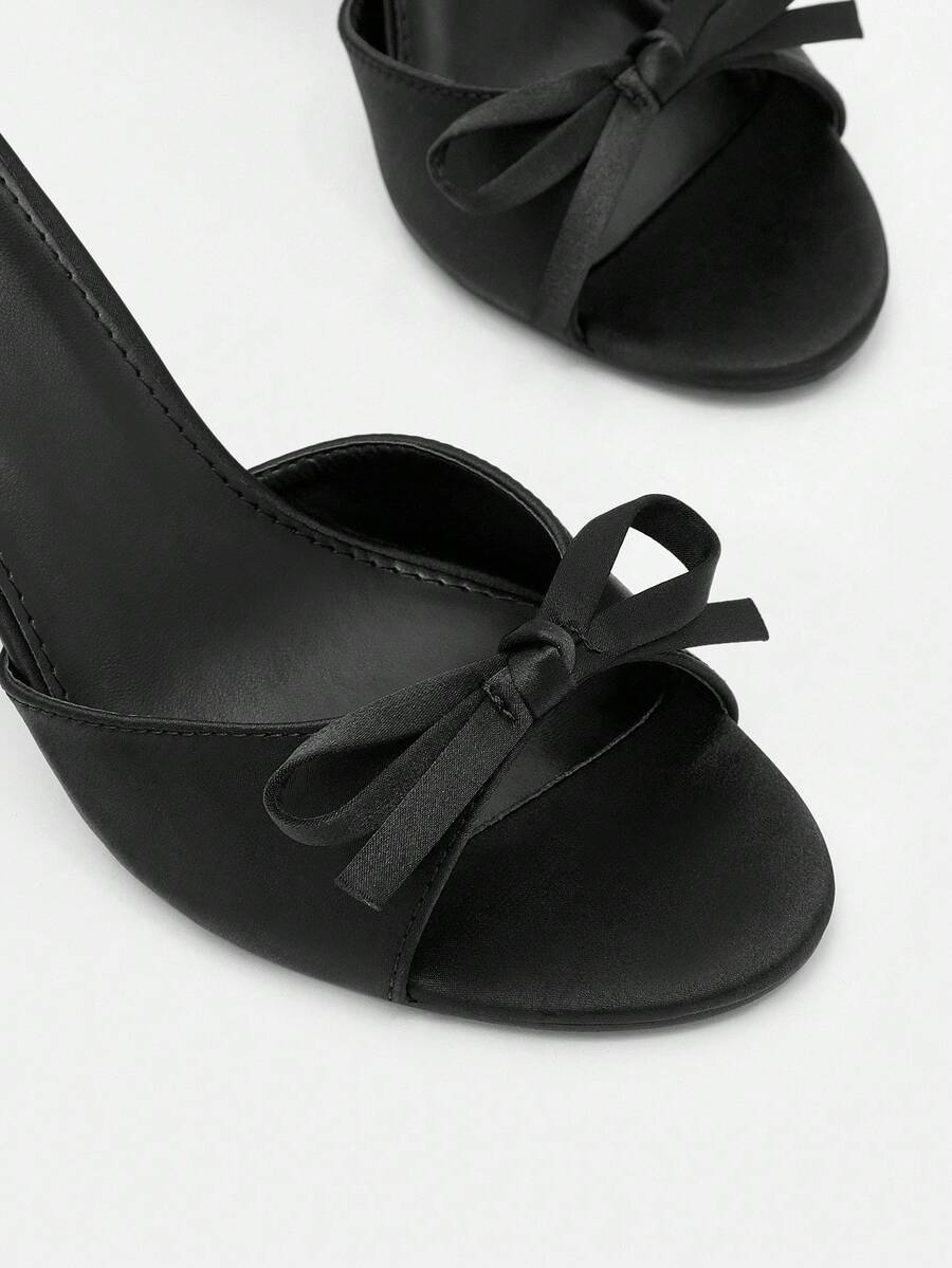 Pair of women's open toe stiletto heeled sandals crafted in satin with a bow accent