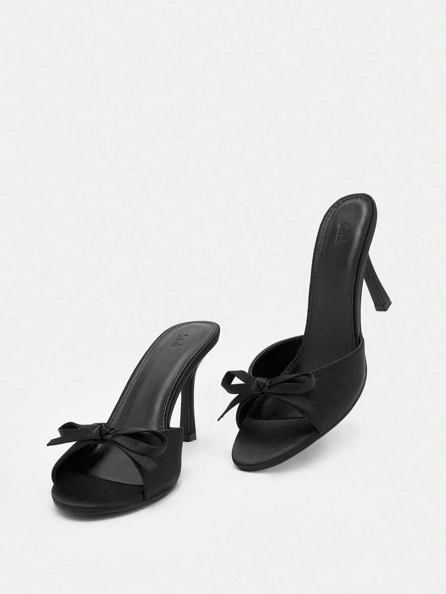 Pair of women's open toe stiletto heeled sandals crafted in satin with a bow accent