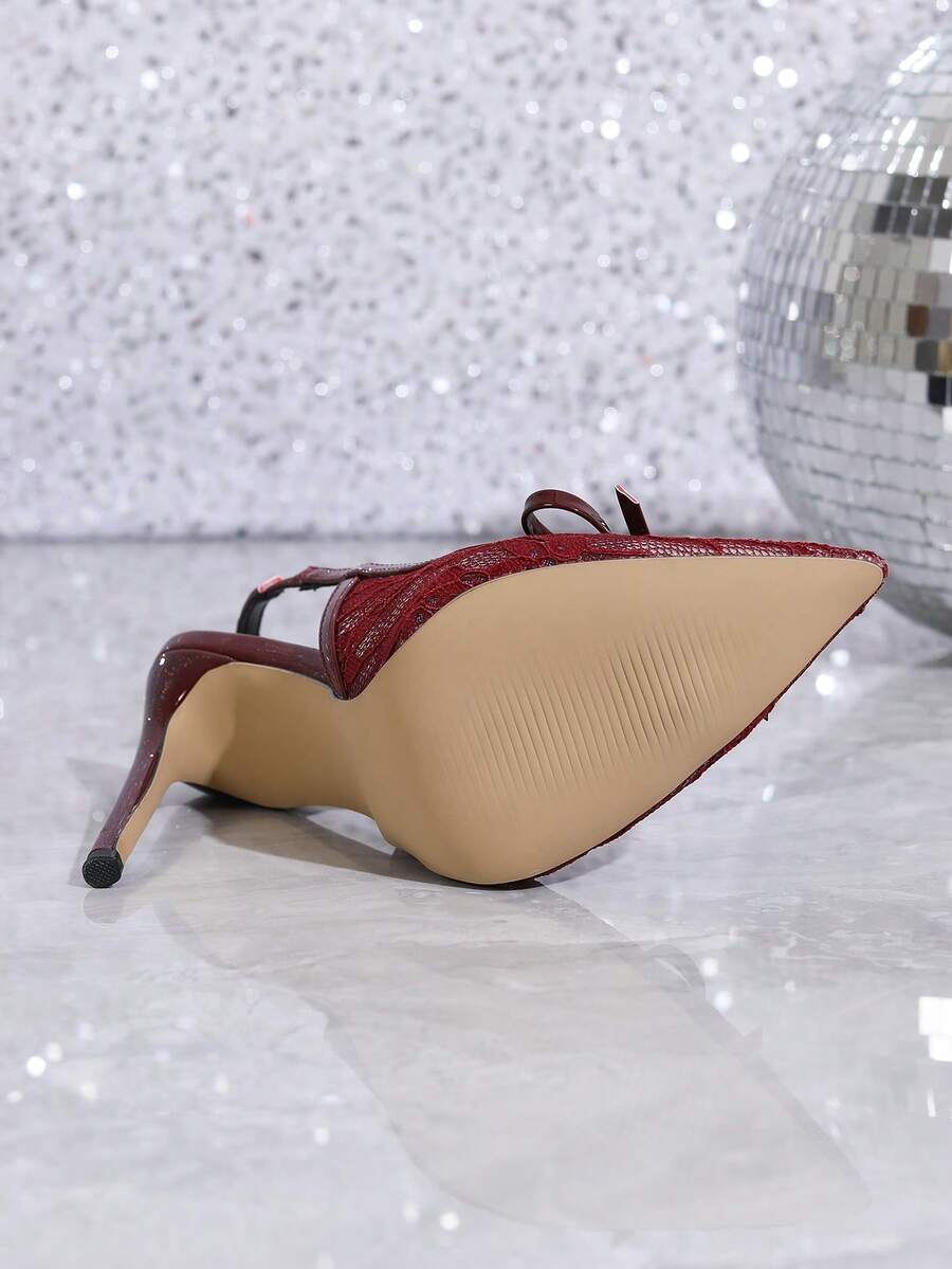Women's pointed toe stiletto high heel pumps featuring a lace bow accent and slingback buckle strap.