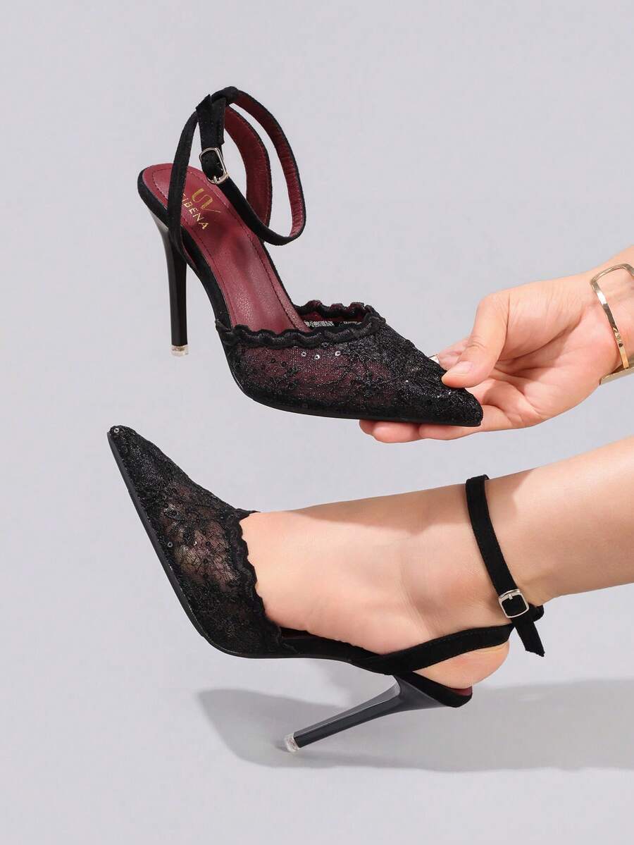 Lace embroidered high heels with thin stiletto heel, pointed toe, rhinestone embellishments, and ankle strap buckle closure.