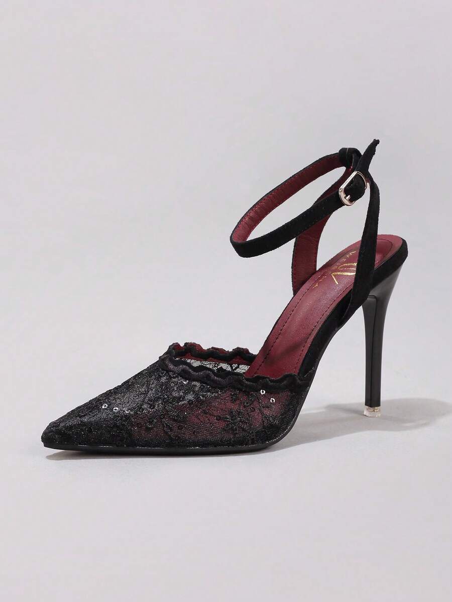 Lace embroidered high heels with thin stiletto heel, pointed toe, rhinestone embellishments, and ankle strap buckle closure.