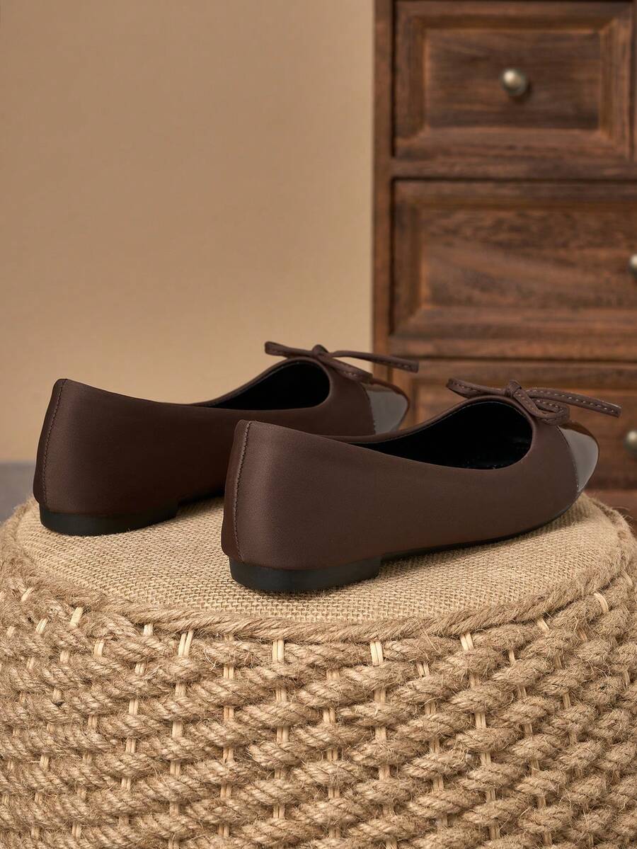 Pair of women's square toe slip-on flat shoes featuring a delicate bow detail and low vamp design.