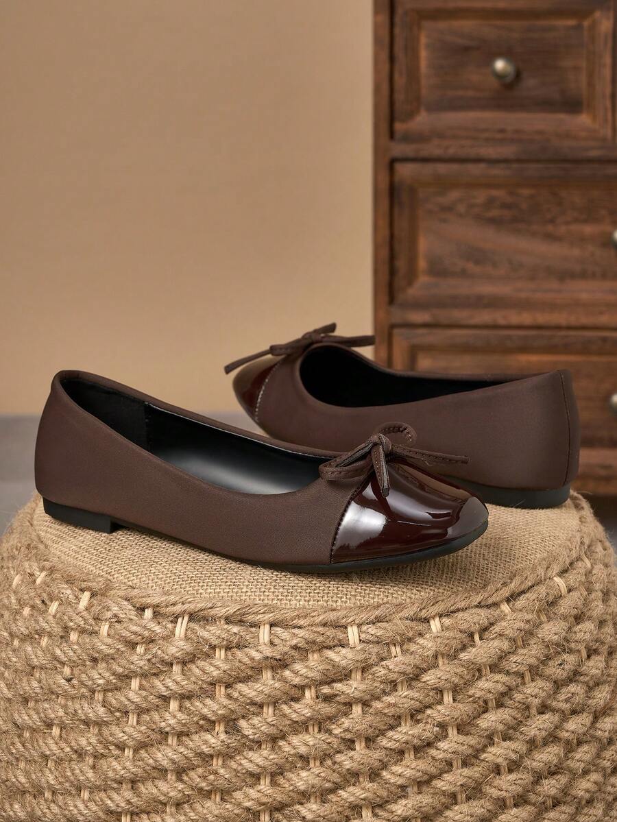 Pair of women's square toe slip-on flat shoes featuring a delicate bow detail and low vamp design.