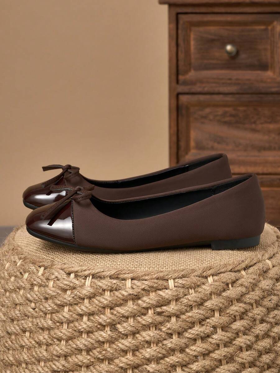 Pair of women's square toe slip-on flat shoes featuring a delicate bow detail and low vamp design.