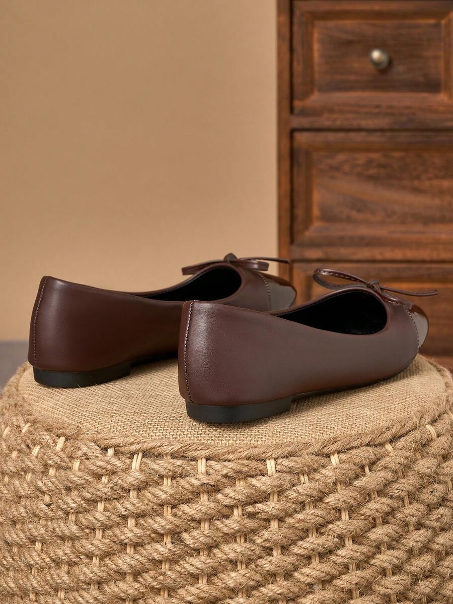 Pair of women's square toe slip-on flat shoes featuring a delicate bow detail and low vamp design.