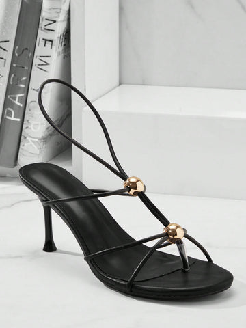Women's strappy stiletto heel sandals crafted in vegan PU leather featuring open toe design and metallic bead accents.